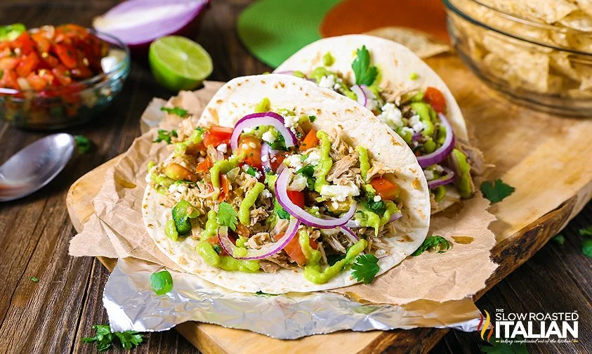 two pork carnitas tacos on flour tortillas with toppings