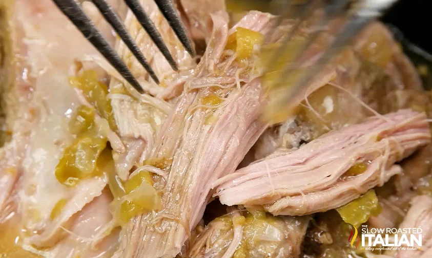 shredding slow cooker carnitas with two forks