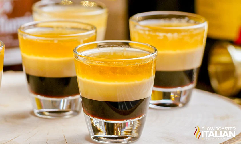 close up: shot glasses of B 52 drink on wooden tray
