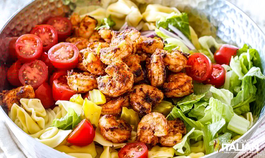 closeup: a big serving bowl of pasta salad with shrimp before mixing