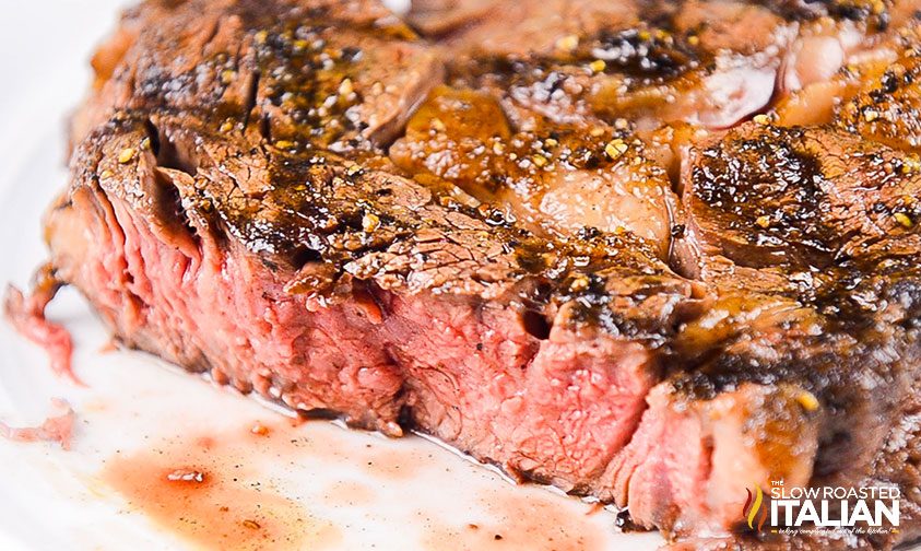 closeup: pink center of ribeye steak on the grill
