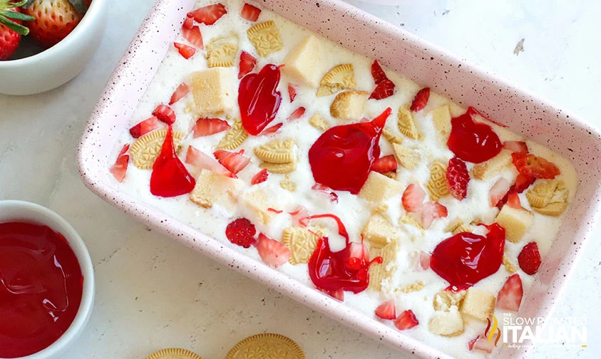 no churn ice cream base dotted with fresh strawberries, berry syrup, Golden Oreo pieces, and cubes of pound cake