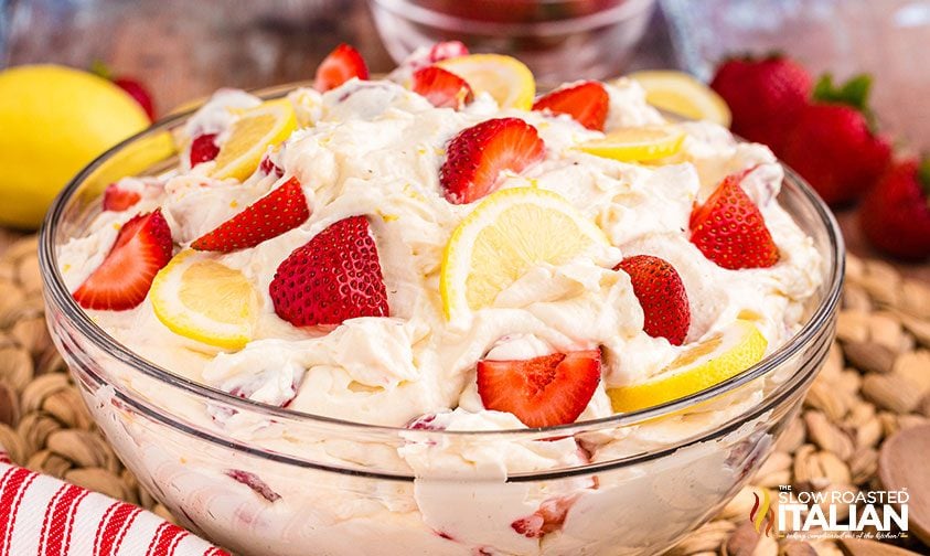 pink lemonade cheesecake salad topped with fresh strawberries and lemon slices
