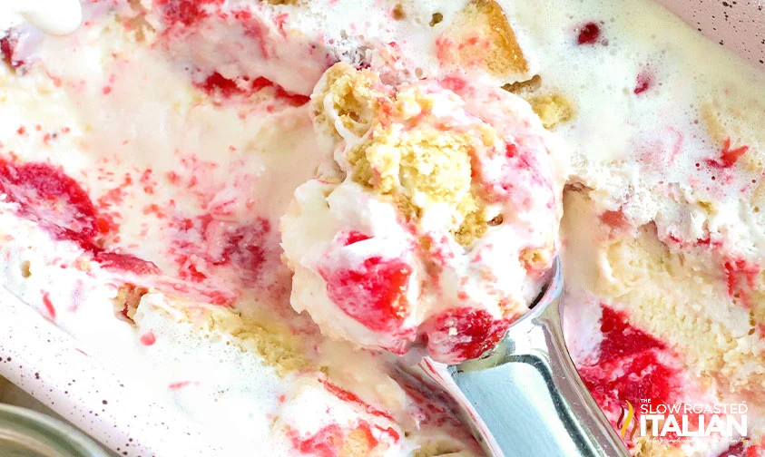 scooping homemade strawberry shortcake ice cream from loaf pan
