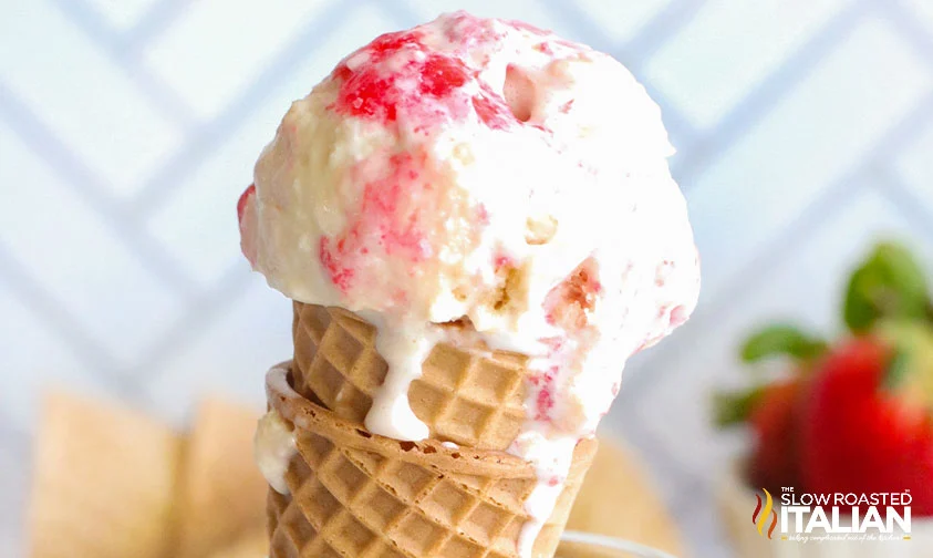 scoop of strawberry shortcake ice cream on stacked waffle cones