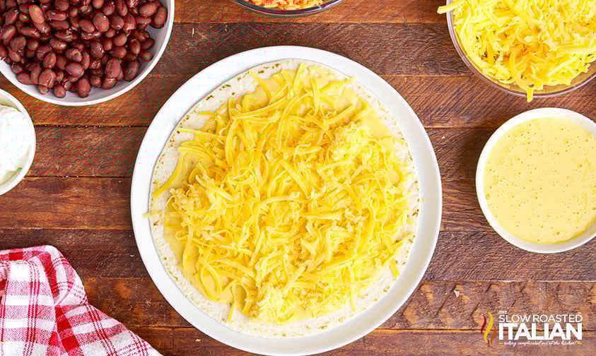 overhead: shredded cheese on tortilla for black bean quesarito
