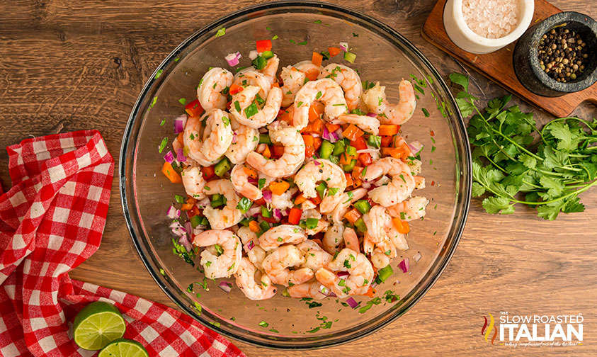 adding lime juice and seasoning to shrimp and veggies