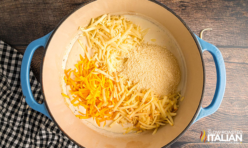 adding shredded cheese to mixture in dutch oven