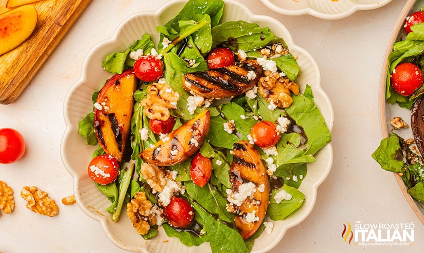 grilled peach salad in a white bowl