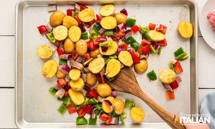 tossing veggies and potatoes in olive oil and seasoning