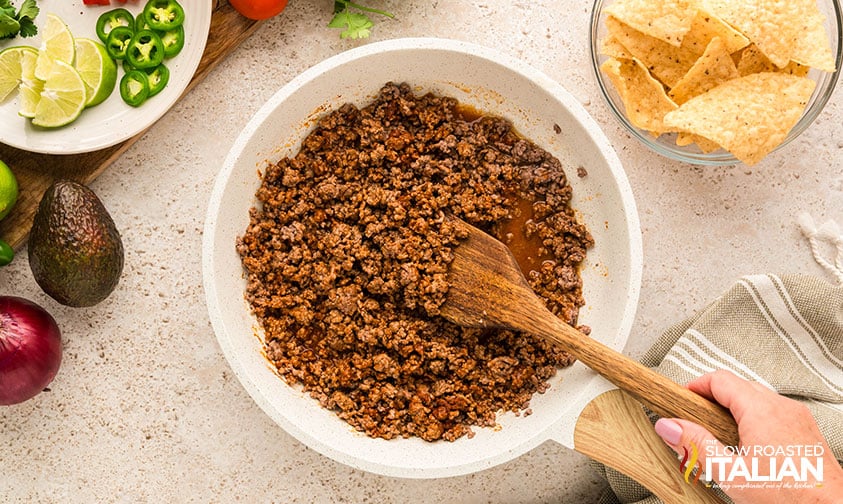 adding seasoning to ground beef for baked nachos