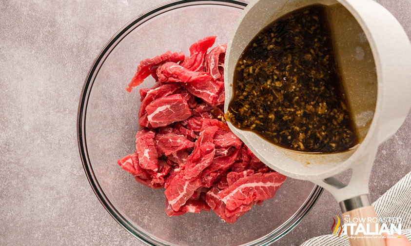 pouring sauce over steak for marinade