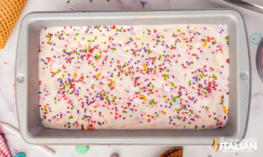 no churn birthday cake ice cream base in metal loaf pan topped with sprinkles