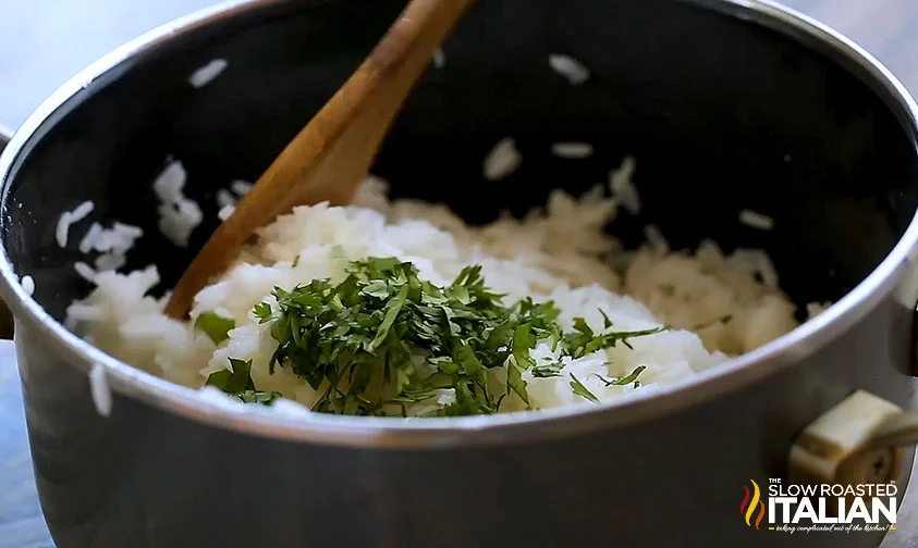 stirring chopped cilantro into cooked rice