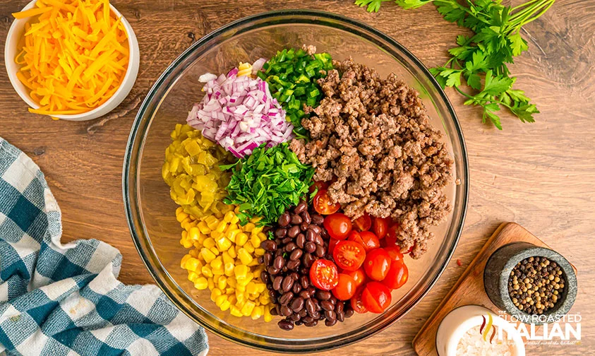 overhead: prepped ingredients for cowboy pasta salad in a bowl