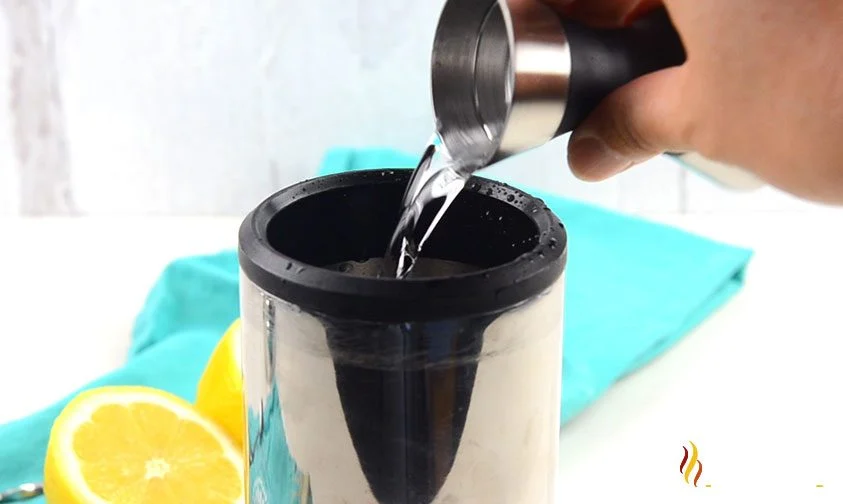 pouring clear liquor into cocktail shaker for long island drink