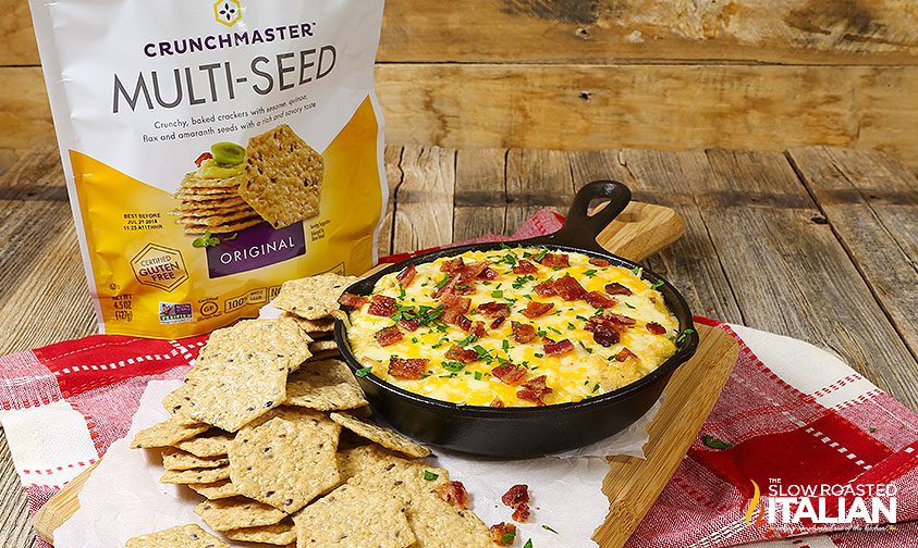 jalapeno popper dip in mini cast iron skillet surrounded by multi-grain crackers