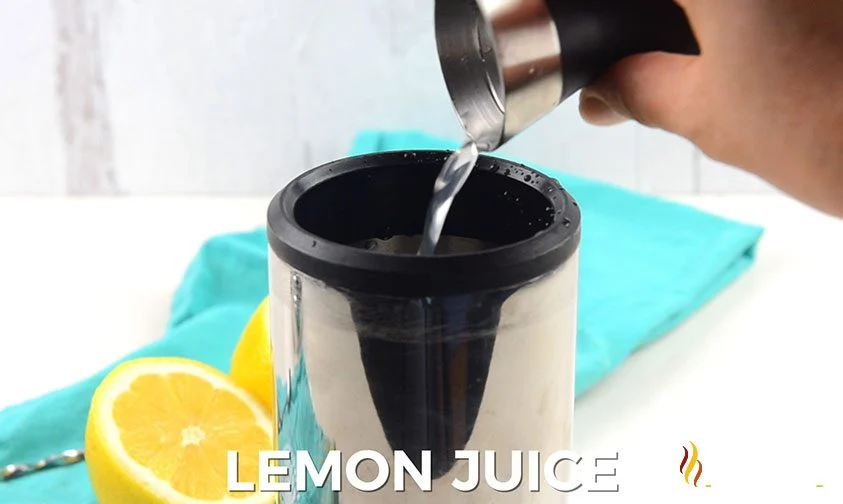 pouring jigger of lemon juice into cocktail shaker to make a long island iced tea