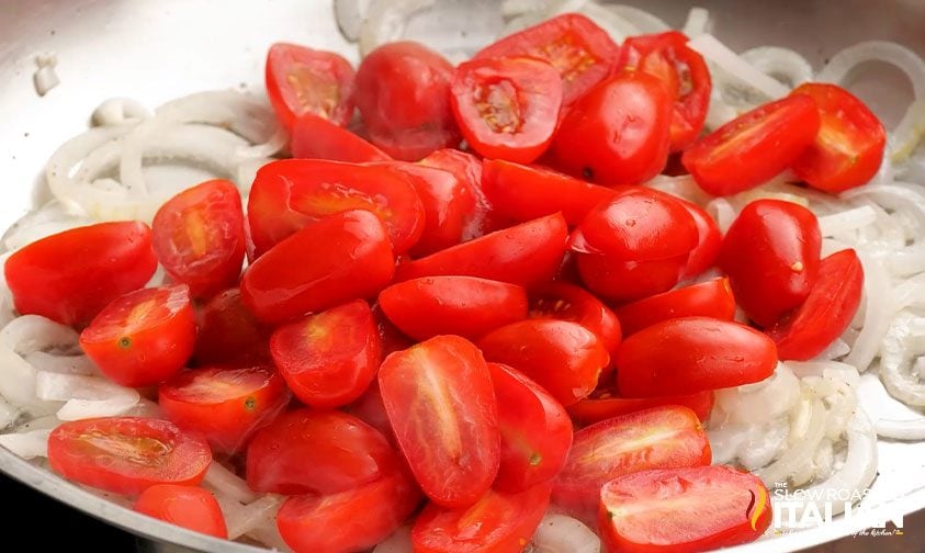 onion slices and halved grape tomatoes in skillet