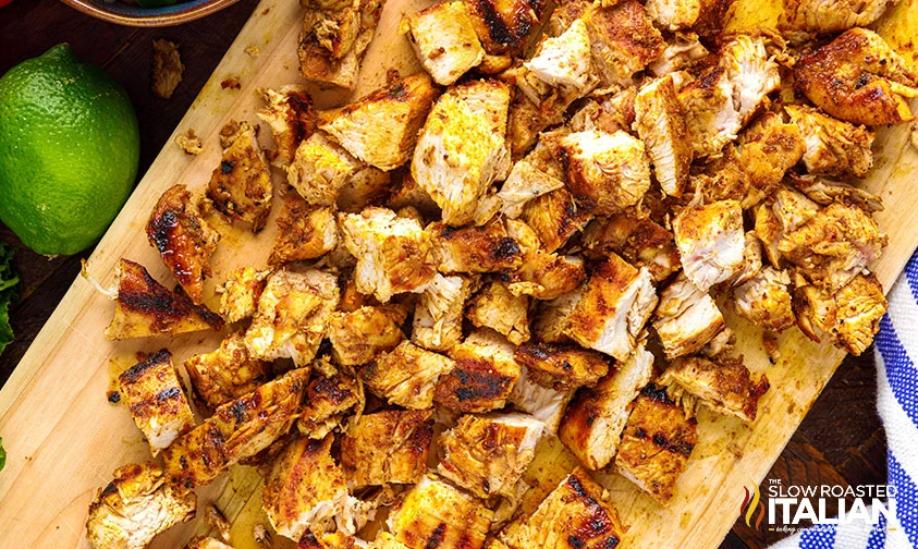 chopped grilled chicken on wooden cutting board