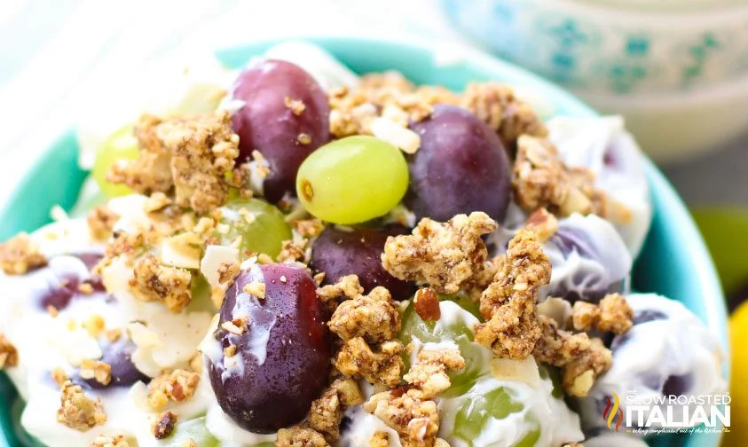closeup: red and green grapes coated in sweet cream cheese mixture topped with granola