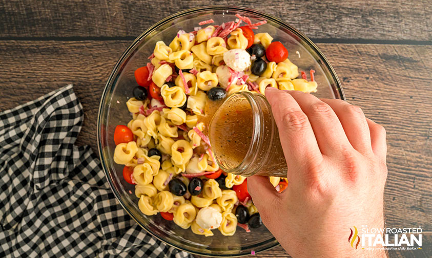 adding dressing to costco tortellini pasta salad