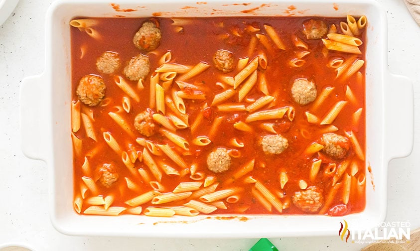 sauce and meatballs added to the uncooked pasta in casserole dish
