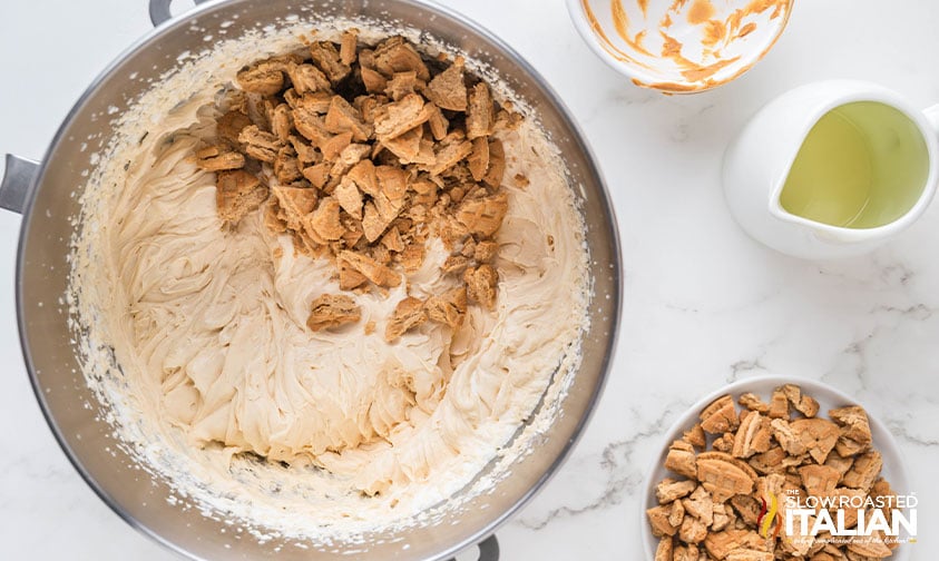 adding chopped nutter butter cookies to whipped cream in mixing bowl