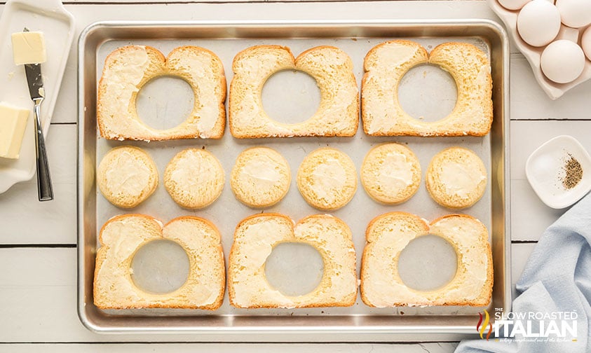 butter spread on slices of bread on a baking sheet