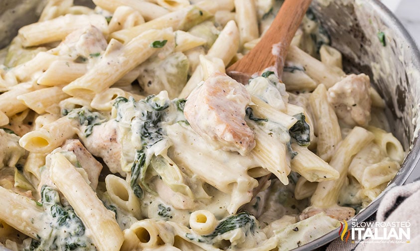 stirring spinach artichoke chicken pasta