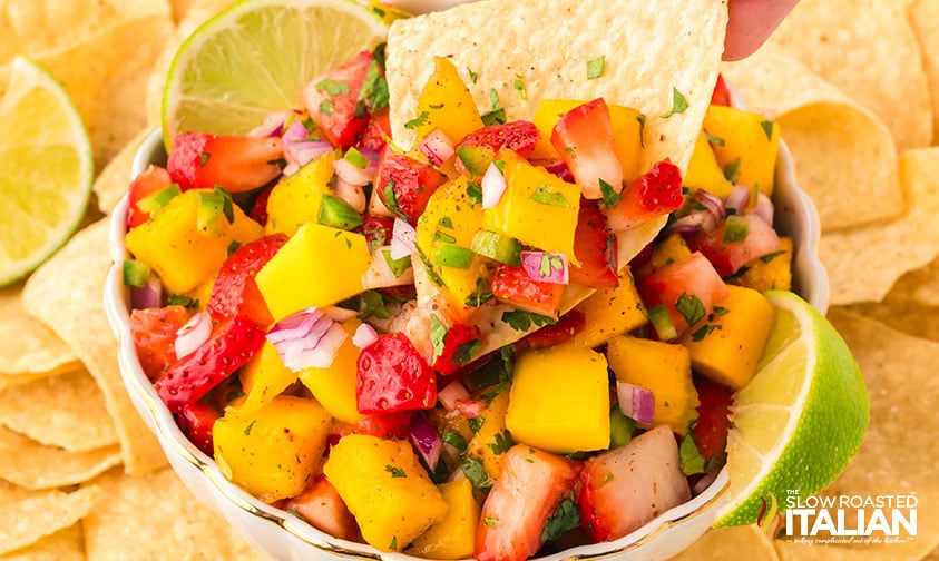 closeup of a chip dipped in strawberry mango salsa
