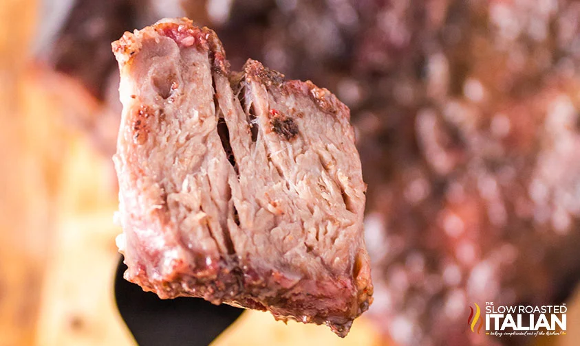 close up: bite of smoked beef chuck roast on a fork