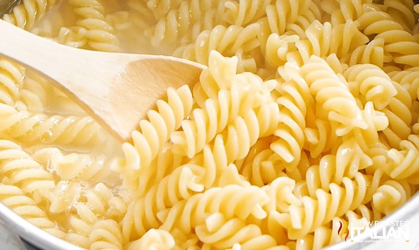 stirring pot of rotini pasta