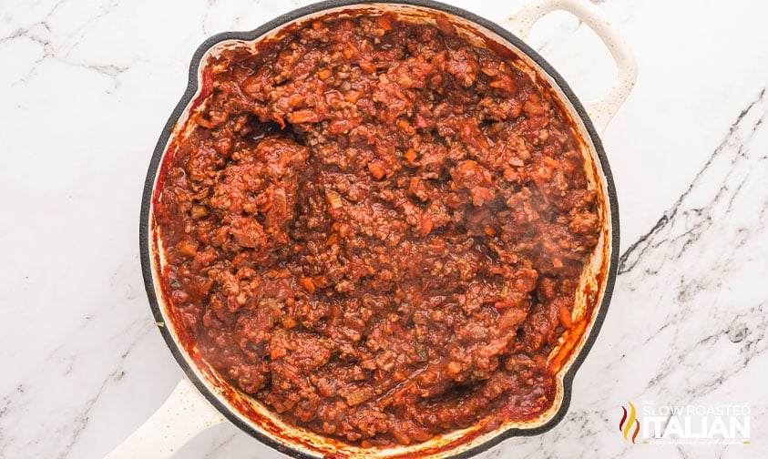 adding bolognese sauce and simmering
