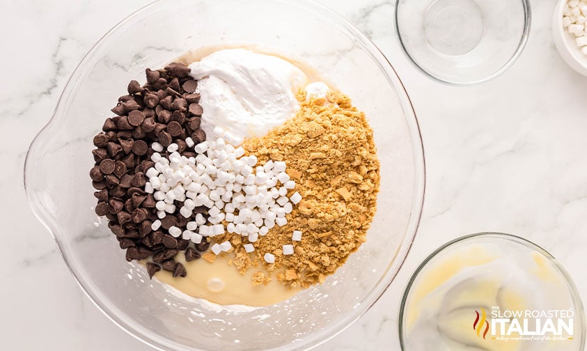 crushed graham crackers, mini marshmallows and chocolate chips added to whipped ice cream base in a large bowl