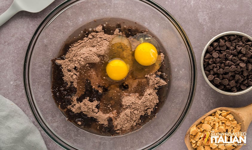 adding eggs to dry cake mix in large mixing bowl