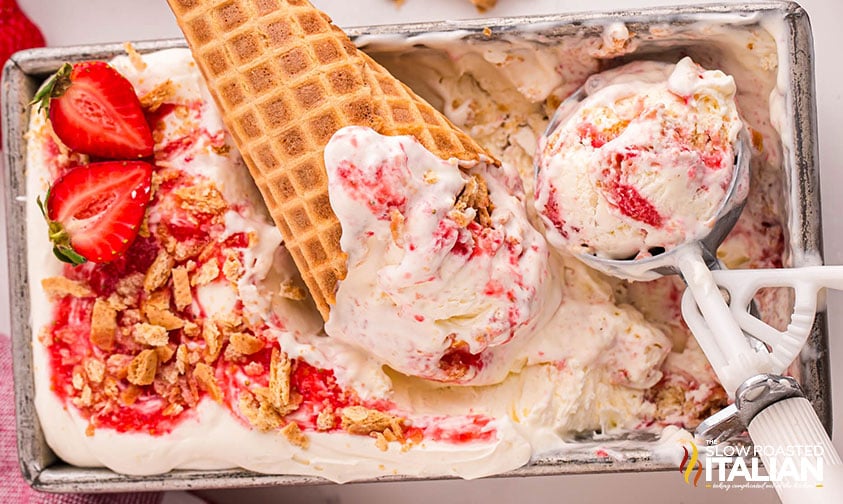 top view of strawberry cheesecake ice cream in a cone and ice cream scoop