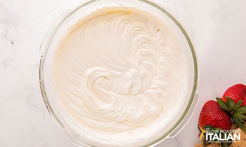 strawberry cheesecake ice cream mixture in a large mixing bowl