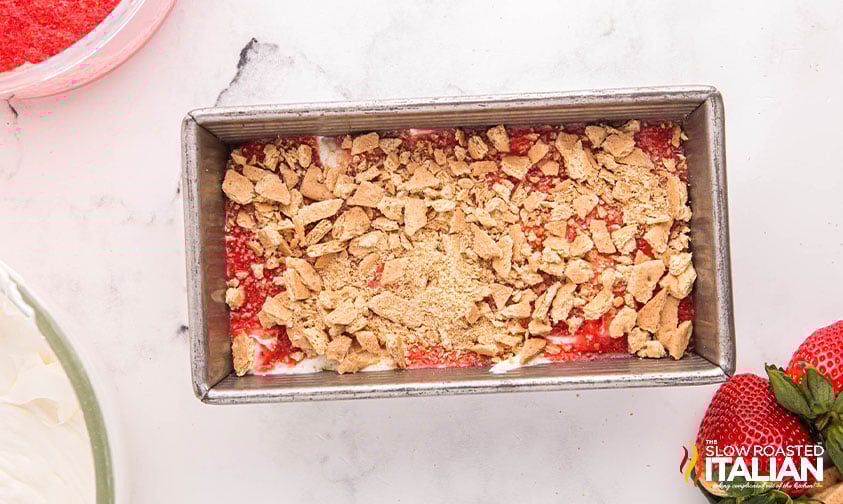 strawberry cheesecake ice cream in a loaf pan with topping