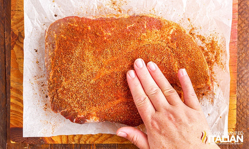 patting dry rub on chuck roast