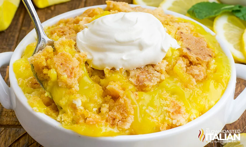 scooping up a bite of lemon dump cake with whipped cream