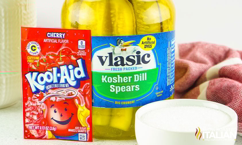jar of pickle spears, packet of cherry Kool-Aid, and bowl of sugar