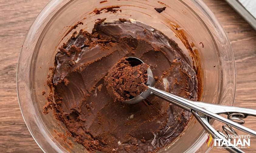 scooping chocolate truffle dough with a cookie scoop