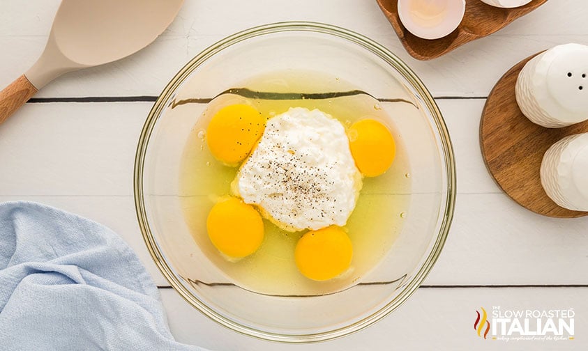 eggs and cottage cheese seasoned with salt and pepper in a bowl