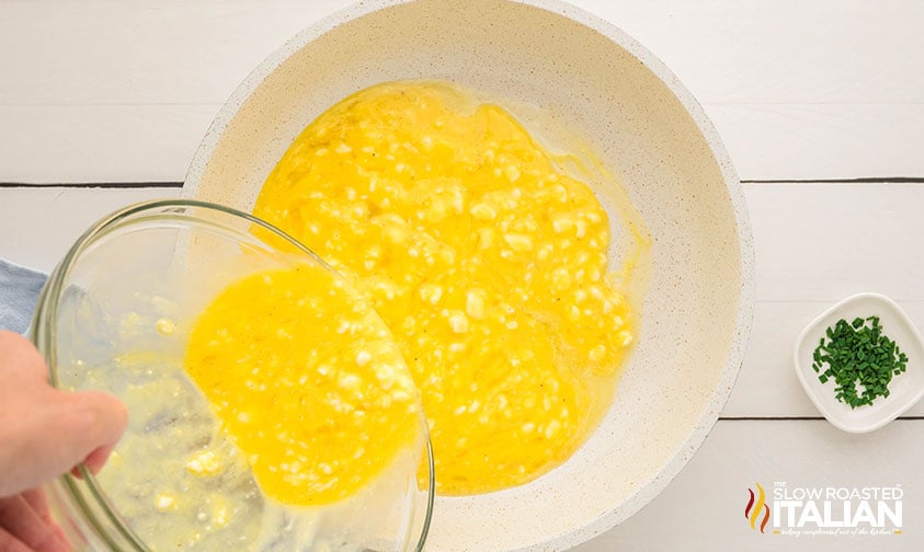 pouring whisked cottage cheese eggs mixture into a skillet