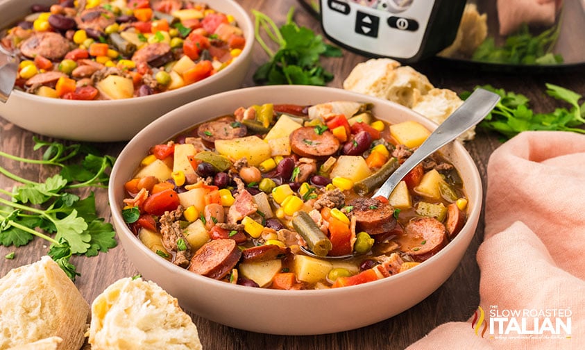 bowls of cowboy stew on a table next to crockpot