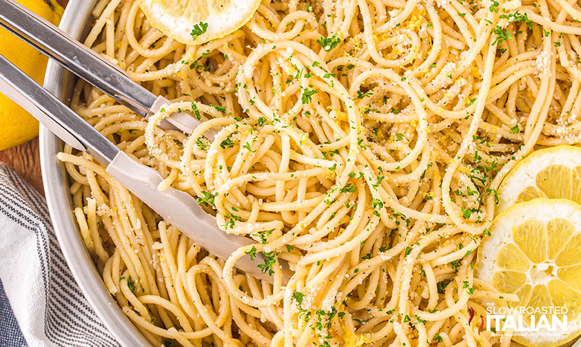 lemon pasta in a skillet with tongs