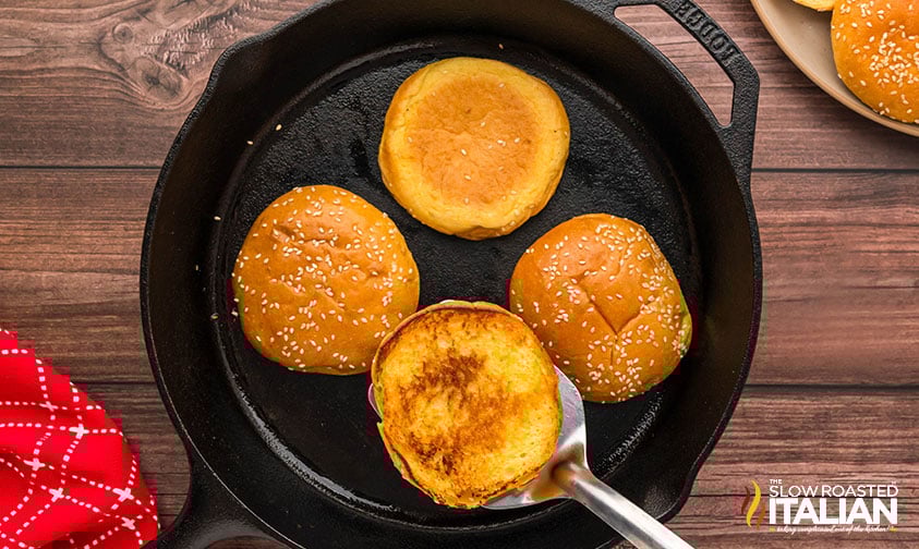 toasting burger buns in a cast iron skillet