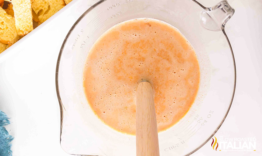 mixing custard for pumpkin pie french toast casserole