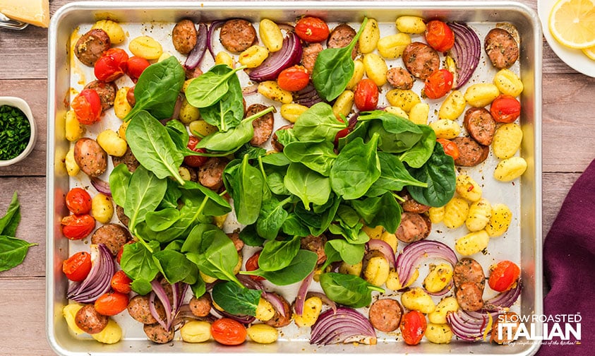 adding spinach to sheet pan gnocchi recipe